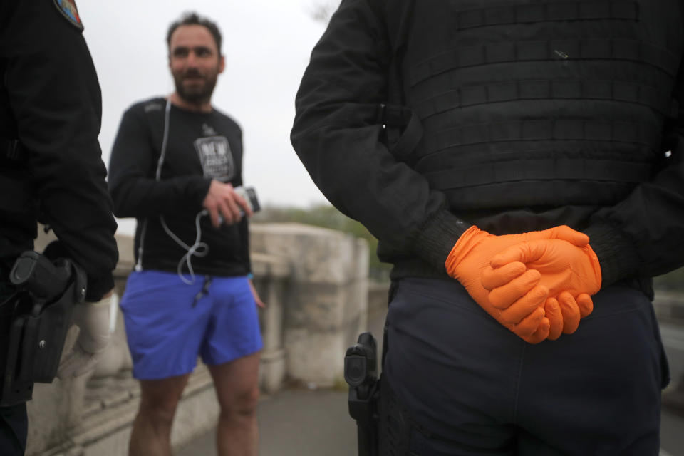 French gendarmes control a man in Paris, Friday, March 20, 2020. French President Emmanuel Macron said that for 15 days people will be allowed to leave the place they live only for necessary activities such as shopping for food, going to work or taking a walk. For most people, the new coronavirus causes only mild or moderate symptoms. For some it can cause more severe illness, especially in older adults and people with existing health problems. (AP Photo/Christophe Ena)