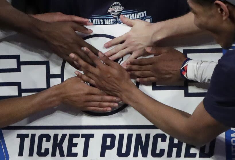 Villanova players stick a logo of their team on a bracket board after defeating Seton Hall 74-72.