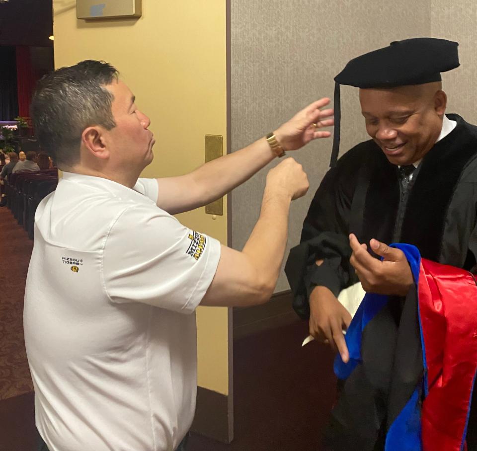 Mun Choi, University of Missouri System president and MU chancellor, on Friday helps Columbia Public Schools  Superintendent Brian Yearwood adjust his tassel before the Douglass High School graduation ceremony in Jesse Auditorium.