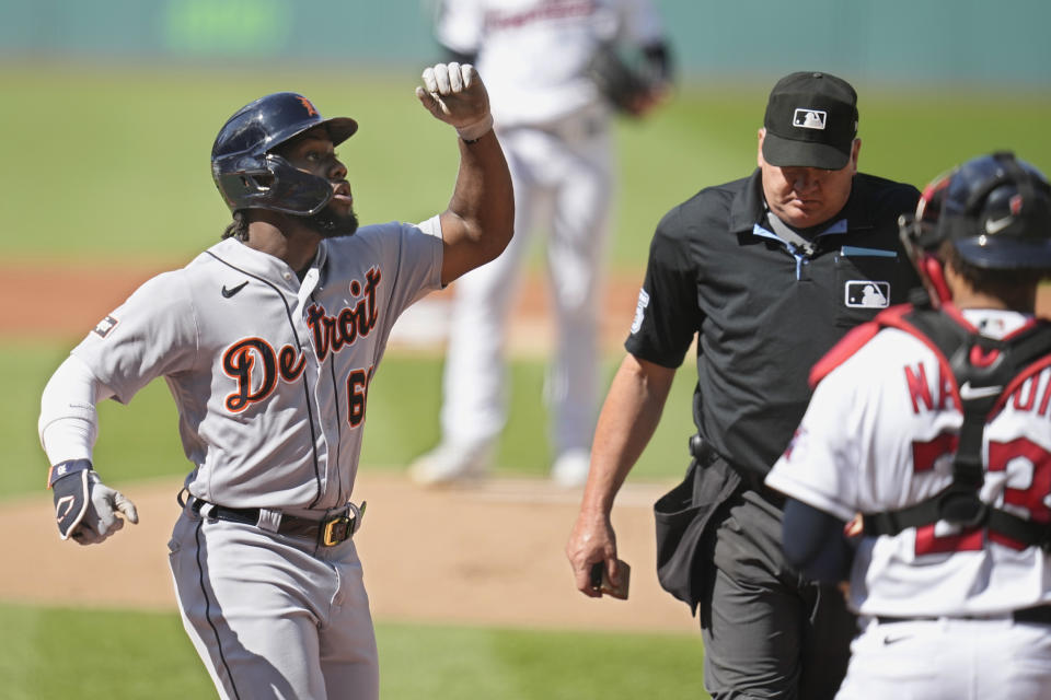 Detroit Tigers' Akil Baddoo gestures crosses home plate after hitting a home run in the first inning in the first baseball game of a doubleheader against the Cleveland Guardians, Friday, Aug. 18, 2023, in Cleveland. Guardians catcher Bo Naylor is at right. (AP Photo/Sue Ogrocki)