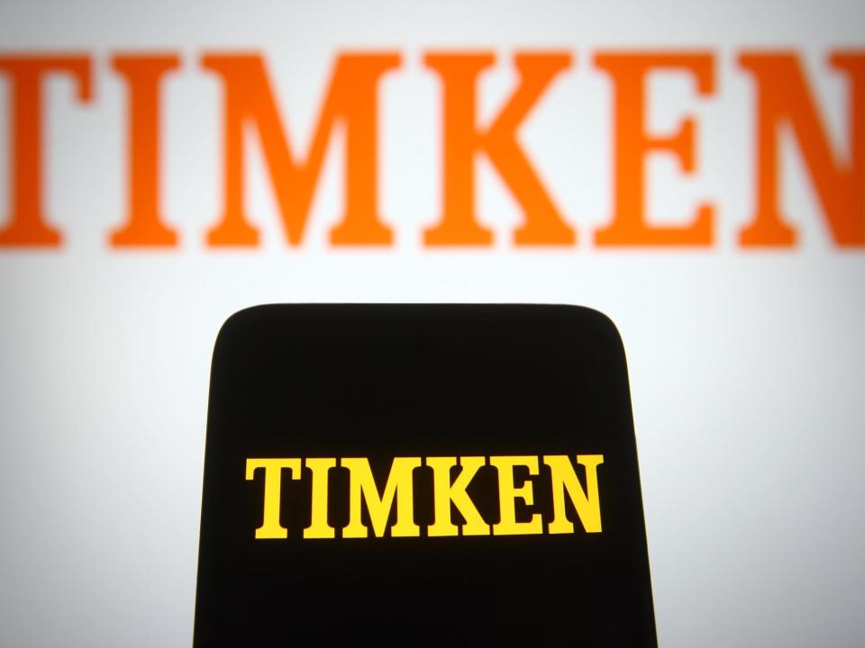 In this photo illustration a Timken Company logo is seen on a smartphone and a pc screen.