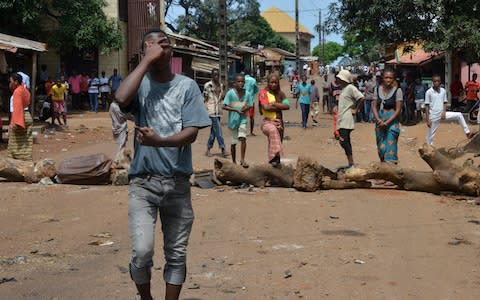 Young people block the road as they protest against a possible third term of President Alpha Conde on October 16, 2019, in Conakry - Credit: AFP