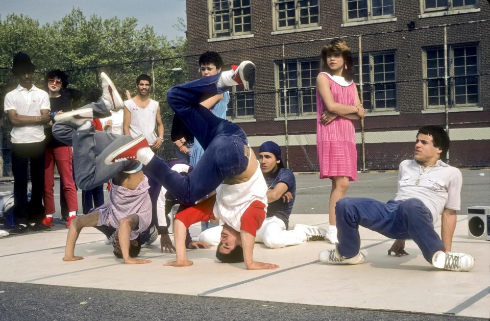 Members of the Rock Steady Crew break-dance in the yard of Booker T. Washington Junior High School (JHS 54), New York, New York, May 8, 1983. The group's co-founder Richard 'Crazy Legs' Colon (red sleeves, center) performs with others.