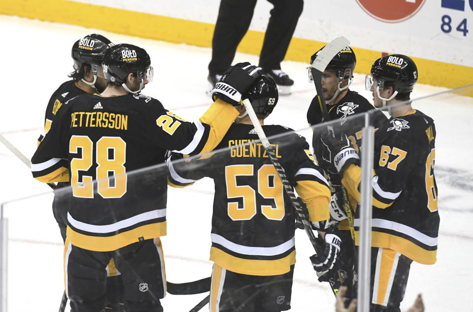 Pittsburgh Penguins defenseman Marcus Pettersson (28) taps left wing Jake Guentzel (59) on the head following a goal against the New York Islanders during an NHL hockey game, Thursday, March 9, 2023, in Pittsburgh. (AP Photo/Philip G. Pavely)