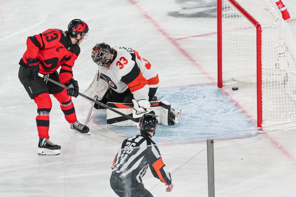 Feb 17, 2024; East Rutherford, New Jersey, USA; New Jersey Devils center Nico Hischier (13) scores a goal past Philadelphia Flyers goaltender Samuel Ersson (33) during the first period in a Stadium Series game at MetLife Stadium. Mandatory Credit: Vincent Carchietta-USA TODAY Sports
