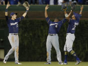 Milwaukee Brewers' Christian Yelich, left, Lorenzo Cain, center, and Keon Broxton celebrate their team's win over the Chicago Cubs in their baseball game Monday, Sept. 10, 2018, in Chicago. (AP Photo/Jim Young)