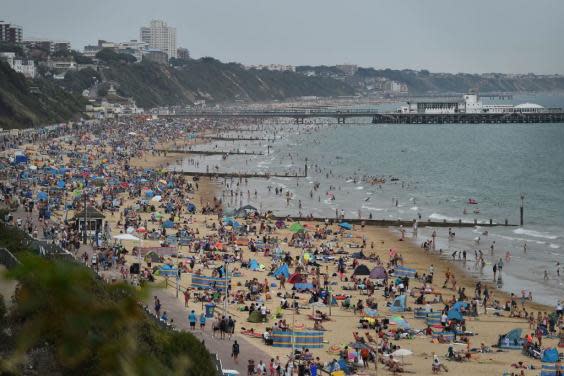 Beachgoers enjoy the sunshine as they sunbathe and play in the sea on Bournemouth beach (Getty Images)