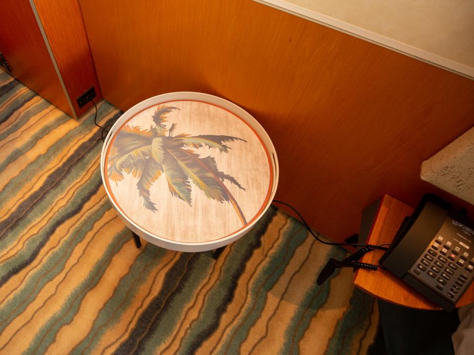 A round nightstand table with a tropical print.