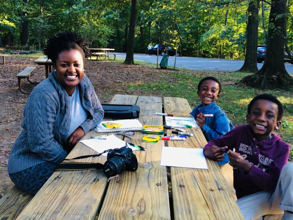 Amanda Miller Littlejohn sitting outside at a picnic table with her two sons when they were younger.