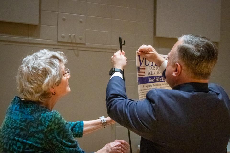 Greene County Clerk Shane Schoeller, right, hangs up a voting information banner with assistance from Election Judge Sue Moore at Second Baptist Church Monday, April 4, in preparation for Greene County's Election Day Tuesday, April 5. Second Baptist Church, located at 3111 E. Battlefield Road, is one of 80 polling places in Greene County. Polling places will be open Tuesday 6 a.m. tp 7 p.m.