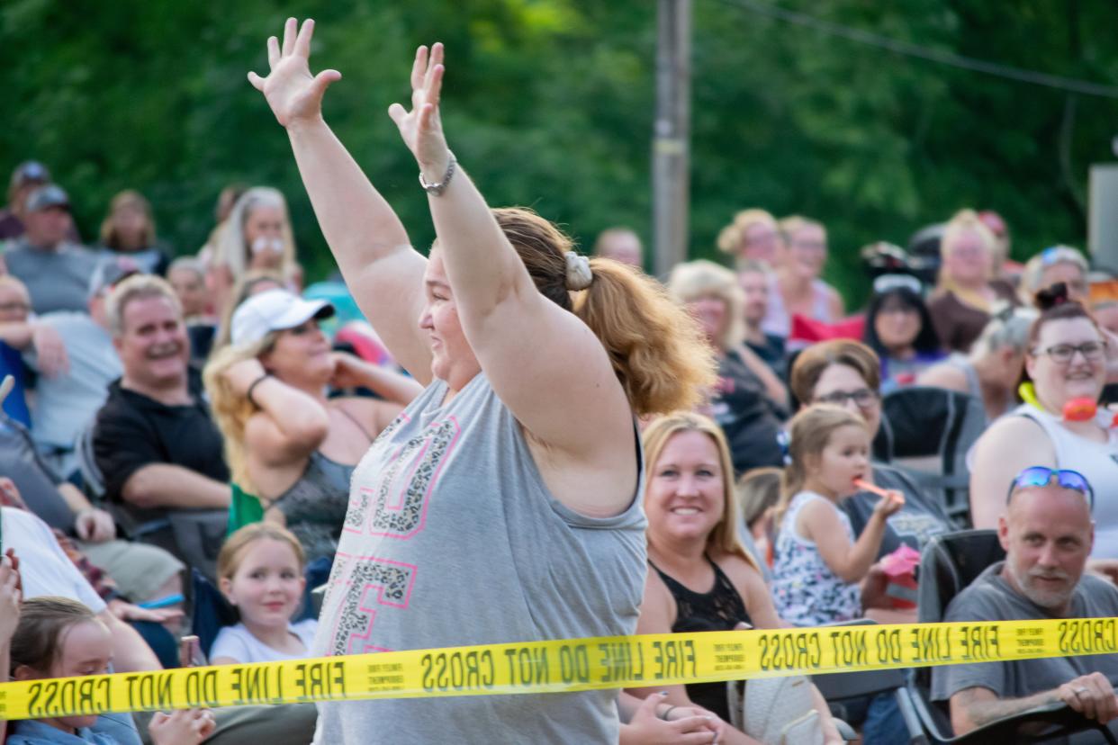 Rachel Watson, of Byesville, throws her hands in the air with delight during the Byesville Firemen's Festival.