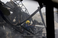 <p>A firefighter sprays water to the site of an explosion at a firecracker factory in Tangerang, on the outskirt of Jakarta, Indonesia, Thursday, Oct. 26, 2017. The explosion and raging fire killed a number of people and injured dozens, police said. (Photo: Tatan Syuflana/AP) </p>