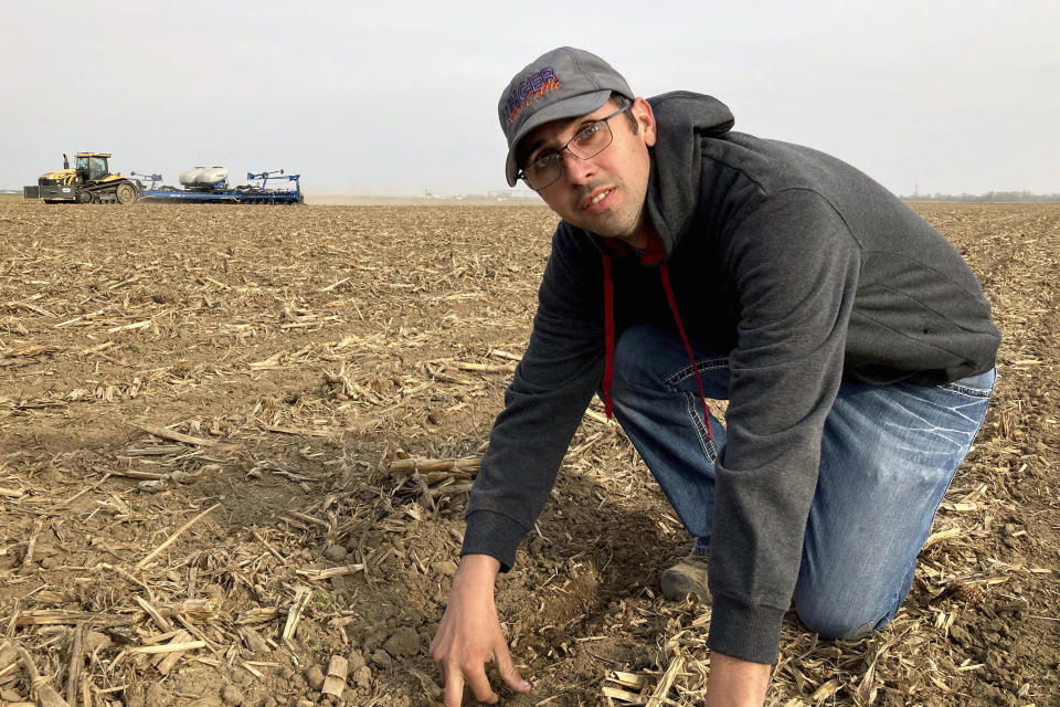 Farmer Lance Unger describes the process of strip tillage, which disturbs the soil less than conventional tillage, in Carlisle, Indiana on April 6, 2021. Unger is among many farmers using minimum tillage, cover cropping and other methods to improve yields while storing more carbon in the soil. “I want to make our farm better for the fourth generation,” he says. (AP Photo/John Flesher)