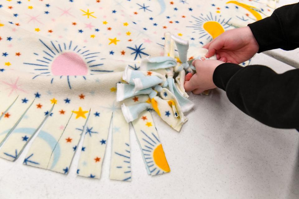 Rosalia Szameit ties a blanket together as part of the Okichiyapi Club's Project Warm-Up on Friday, November 12, 2021, at Washington High School in Sioux Falls.