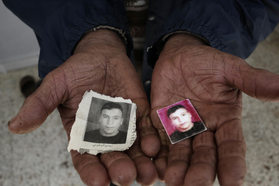 The father of Majdi Al Barhoumi, who went missing in 2011, holds photos of him, at their home in the town of Ras Jabal, Bizerte, Tunisia, on April 12, 2018. As global migration has soared to record highs, far less visible has been its toll: The tens of thousands of people who die or simply disappear during their journeys, never to be seen again. (AP Photo/Nariman El-Mofty)