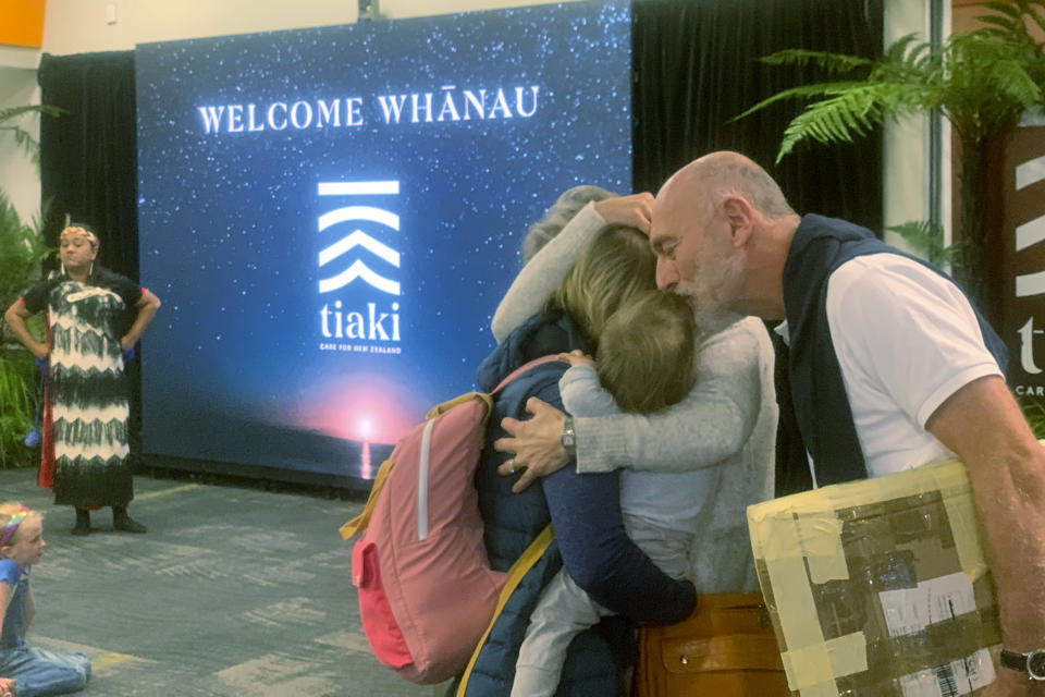 Passengers arriving from Sydney at the Wellington International Airport hug loved ones in Wellington, New Zealand Monday, April 19, 2021. The start of quarantine-free travel was a relief for families who have been separated by the coronavirus pandemic as well as to struggling tourist operators. (AP Photo/Nick Perry)