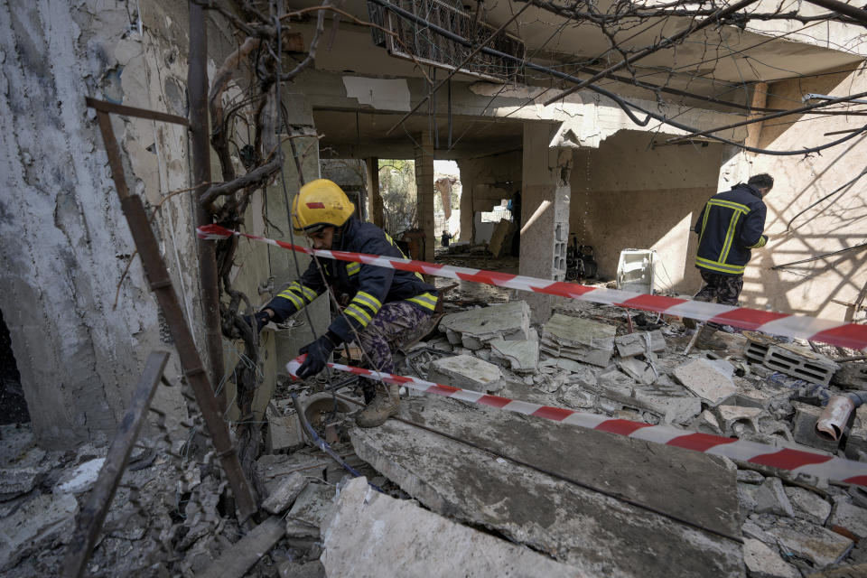 Palestinian rescuers inspect the site of a damaged building following an Israeli forces raid in the West Bank city of Jenin, Thursday, Jan. 26, 2023. Israeli forces killed at least nine Palestinians, including a 60-year-old woman, and wounded several others during a raid in the flashpoint area of the occupied West Bank, Palestinian health officials said, in one of the deadliest days of fighting in years. The Israeli military said it was conducting an operation to arrest militants when a gun battle erupted. (AP Photo/Majdi Mohammed)