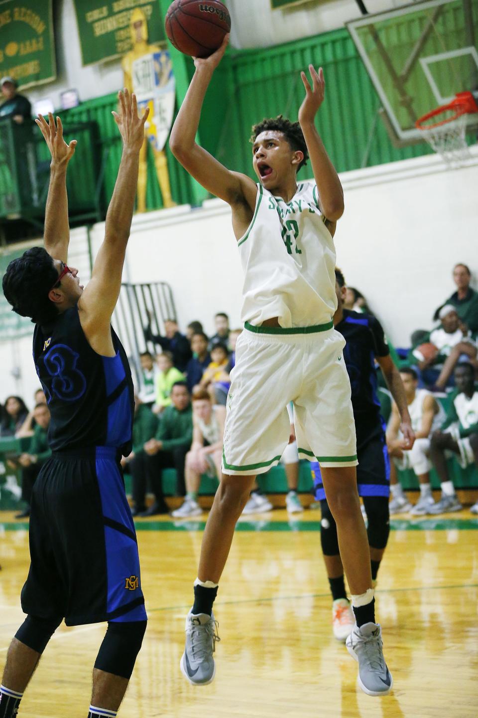 St. Mary’s Kj Hymes (42) shoots over Shadow Mountain forward Tyler Jafary (33) during the second half at the St. Mary's High School gym in Phoenix on Jan. 24, 2017.