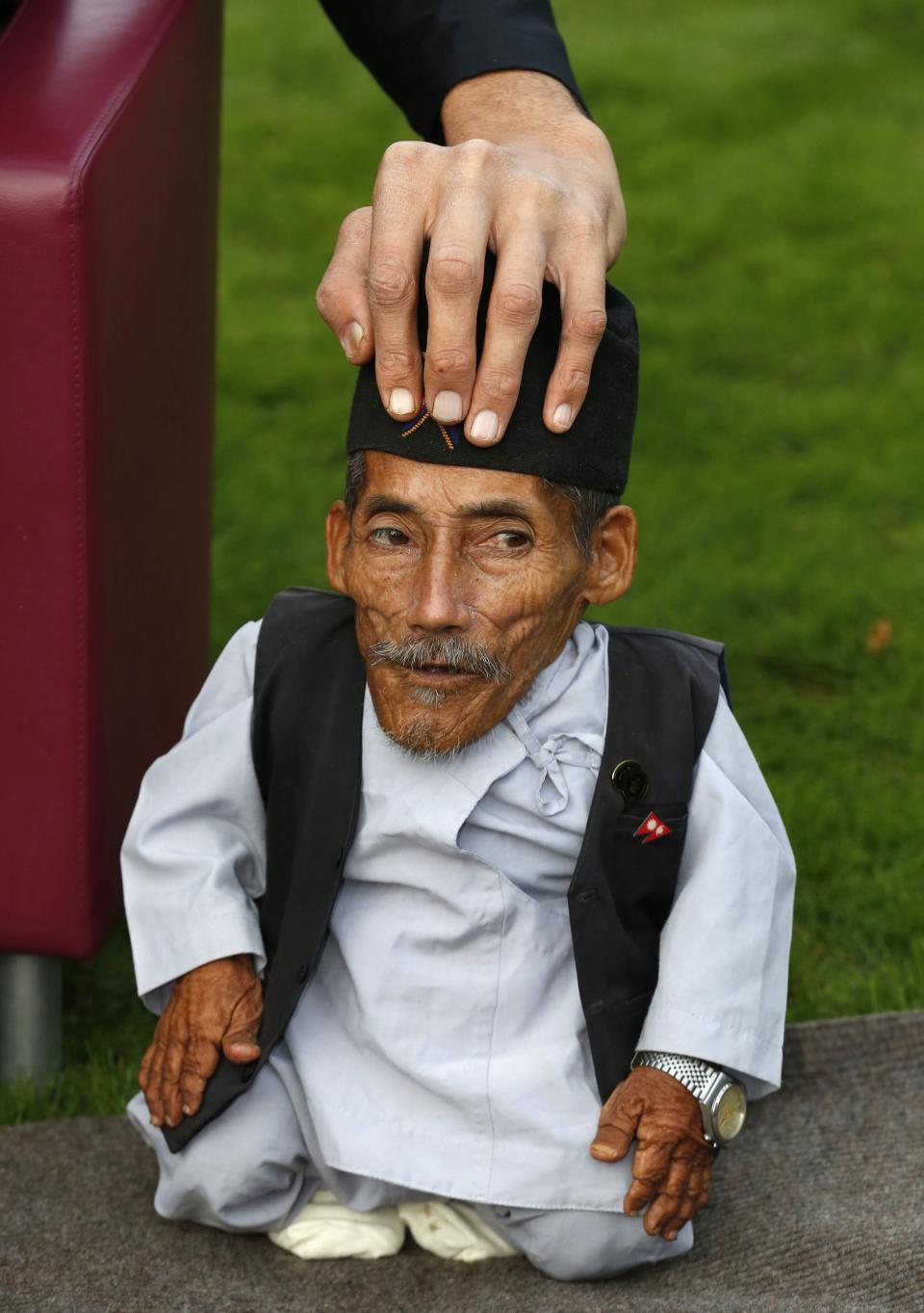 The tallest living man Sultan Kosen touches the head of the world's shortest man Chandra Bahadur Dangi  as they pose to mark the Guinness World Records Day in London