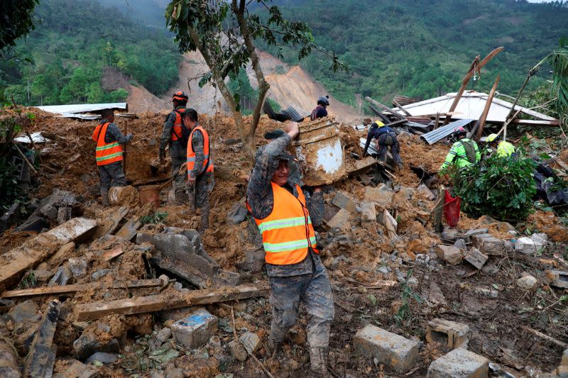 FILE PHOTO: Soldiers remove debris and mud from an area hit by a mudslide, caused by heavy rains brought by Storm Eta, as the search for victims continue in the buried village of Queja