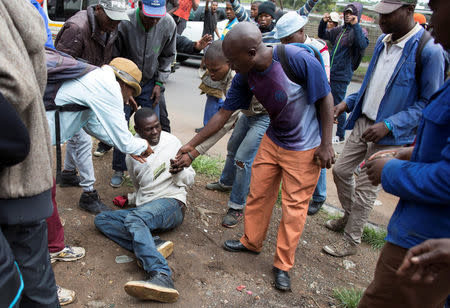 A man holds his South African identity document after being attacked by a mob in Pretoria, South Africa, February 24, 2017. REUTERS/ James Oatway.REUTERS/James Oatway