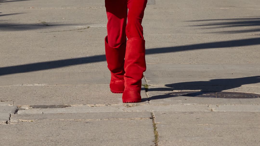 a model in a red sweatsuit walks the outdoor runway at balenciaga's fall 2024 show in la