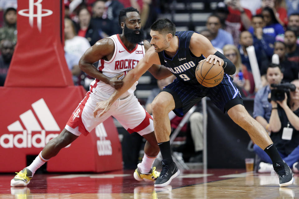 Orlando Magic center Nikola Vucevic (9) attempts to drive around Houston Rockets guard James Harden, left, during the first half of an NBA basketball game Sunday, March 8, 2020, in Houston. (AP Photo/Michael Wyke)