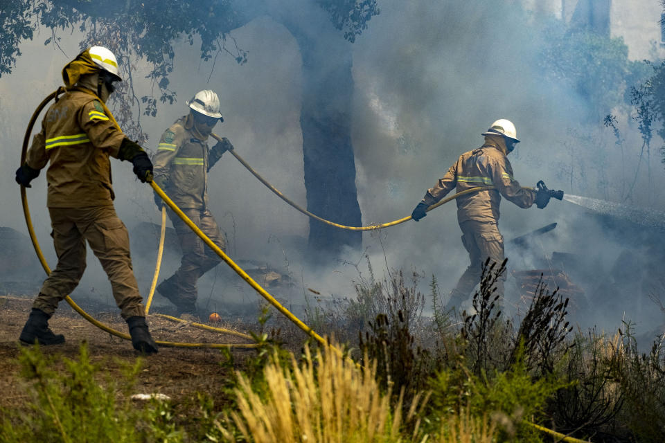 Firefighters try to extinguish a wildfire near Colos village, in central Portugal on Monday, July 22, 2019. More than 1,000 firefighters battled Monday in torrid weather against a major wildfire in Portugal, where every summer forest blazes wreak destruction. (AP Photo/Sergio Azenha)