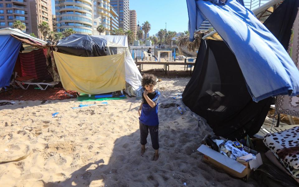 A child stands amid tents on the Ramlet al-Bayda public beach in Beirut, where people who fled Israeli bombing took refuge