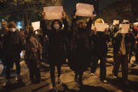 FILE - Protesters hold up blank papers and chant slogans as they march in protest in Beijing, Sunday, Nov. 27, 2022. The recent wave of protests against China's anti-virus restrictions was a ray of hope for some supporters of Hong Kong's own pro-democracy movement after local authorities stifled it using a national security law enacted in 2020, but not everyone agrees. (AP Photo/Ng Han Guan, File)