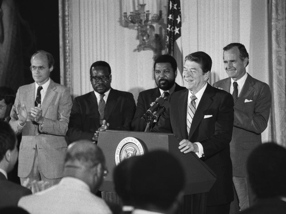 Clarence Thomas stands behind former President Ronald Reagan in 1984.