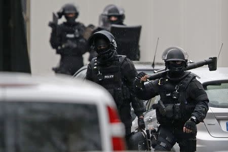 Members of French special police forces of Research and Intervention Brigade (BRI) are seen at the scene of a shooting in the street of Montrouge near Paris January 8, 2015. A policewoman was killed in a shootout in southern Paris on Thursday, triggering searches in the area as the manhunt widened for two brothers suspected of killing 12 people at a satirical magazine in an apparent Islamist militant strike. REUTERS/Charles Platiau