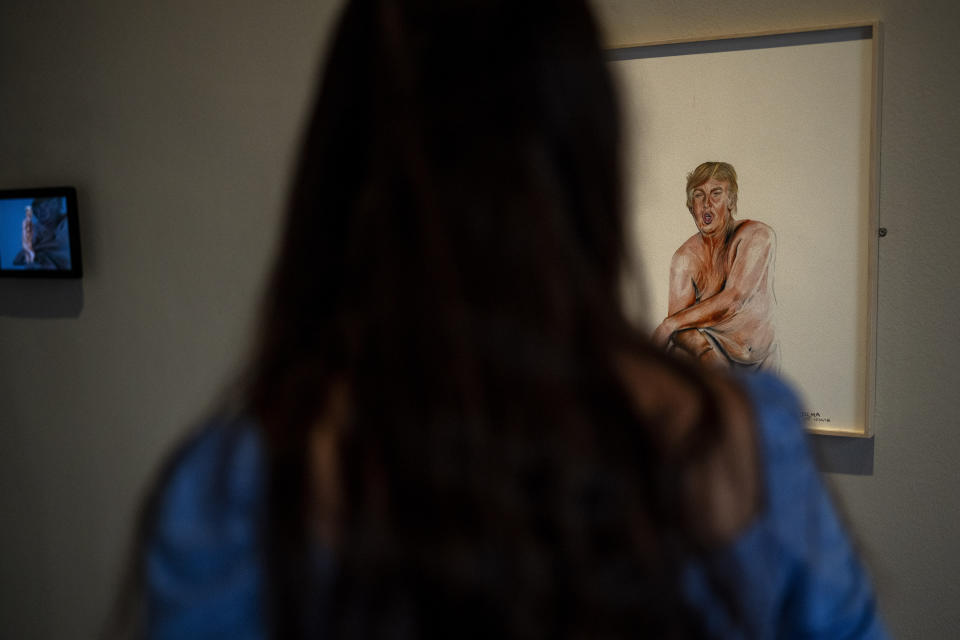 A visitor looks at a drawing of a nude Donald Trump by artist Illma Gore, exhibited at Barcelona's Museum of Forbidden Art in Barcelona, Spain, Friday, Nov. 17, 2023. In 2016, the Australian artist Illma Gore posted her artwork on Facebook and had her account shut down to obscenity and nudity. In addition, Gore received death threats online and a Trump supporter punched her in the street. A new museum in Barcelona is offering a second chance to controversial artworks that have suffered censorship for religious, sexual, political or commercial reasons. (AP Photo/Emilio Morenatti)