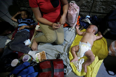 Children sleep on the floor along other Hondurans fleeing poverty and violence, before moving in a caravan toward the United States, outside the bus station in San Pedro Sula, Honduras October 13, 2018. REUTERS/Jorge Cabrera