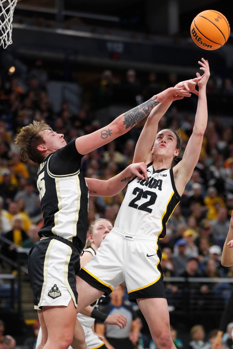 Purdue forward Rickie Woltman, left, knocks the ball away from Iowa guard Caitlin Clark (22) during the first half of an NCAA college basketball game at the Big Ten women's tournament Friday, March 3, 2023, in Minneapolis. (AP Photo/Bruce Kluckhohn)