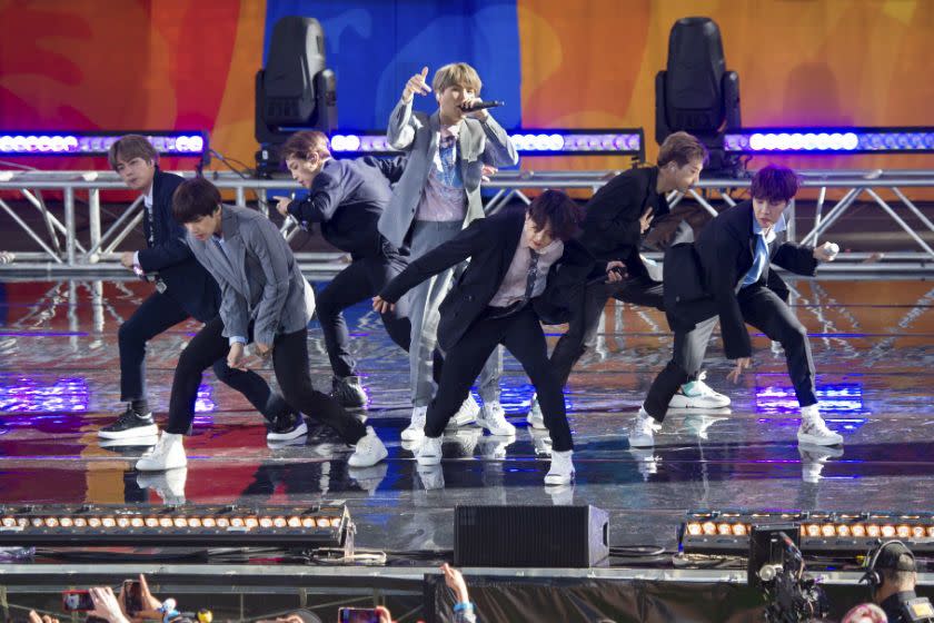 A group of men in suits singing and dancing on a stage