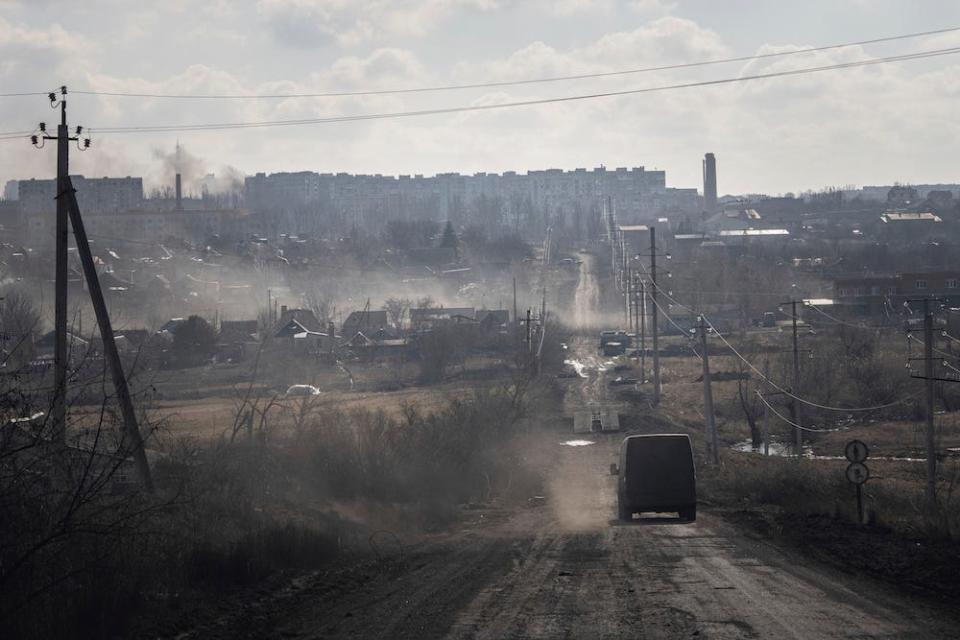 A vehicle on the road to Bakhmut via Khromove, amid dust and smoke, on March 4, 2023