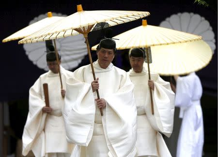 Shinto priests holding traditional umbrellas walk to the main shrine for a ritual to cleanse themselves during the annual Spring Festival at the Yasukuni Shrine in Tokyo, Japan, April 21, 2016. REUTERS/Issei Kato