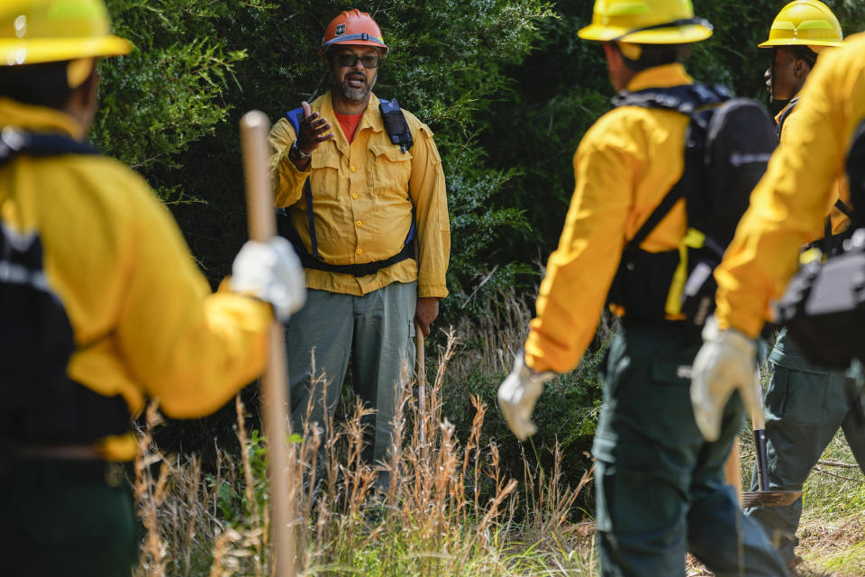 Wildland firefighter instructor James Klungness-Mshoi, center, gives instructions to students during a wildland firefighter training Friday, June 9, 2023, in Hazel Green, Ala. A partnership between the U.S. Forest Service and four historically Black colleges and universities is opening the eyes of students of color who had never pictured themselves as fighting forest fires. (AP Photo/George Walker IV)