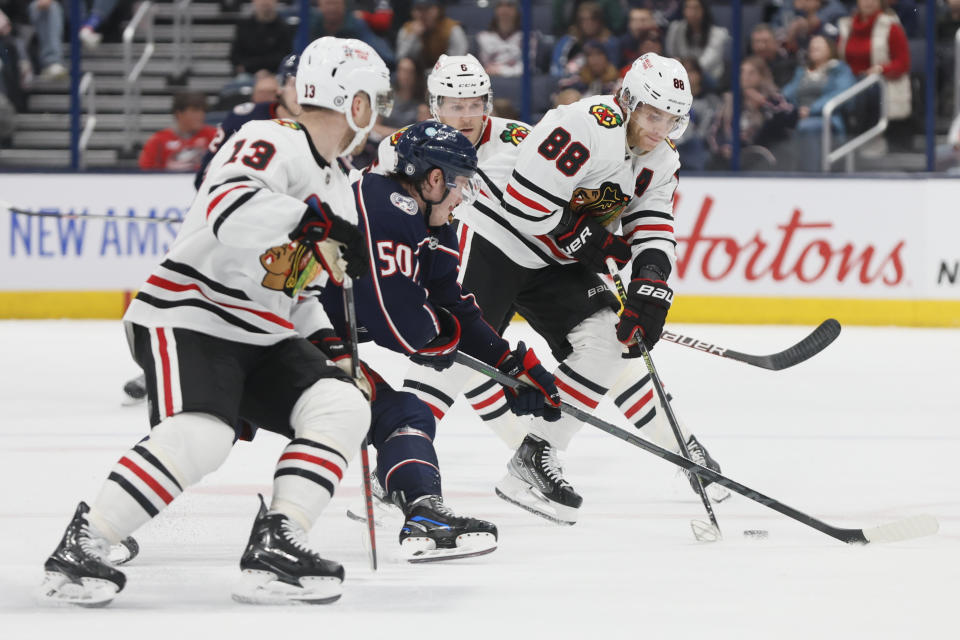 Chicago Blackhawks' Patrick Kane, right, controls the puck as Columbus Blue Jackets' Eric Robinson defends during the third period of an NHL hockey game on Saturday, Dec. 31, 2022, in Columbus, Ohio. (AP Photo/Jay LaPrete)