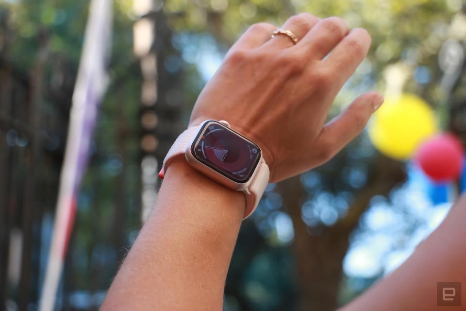 Foto einer Person, die die Apple Watch Series 9 am linken Handgelenk trägt.  Die Aufnahme reicht von der Hand bis zum Unterarm, während die Person ihr Handgelenk hochhält, um das Zifferblatt zu sehen.