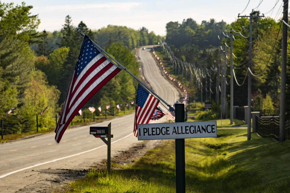 U.S. flags and signs with the words to the Pledge of Allegiance line U.S. 1 in Columbia Falls, Maine, Saturday, May 27, 2023. (AP Photo/Robert F. Bukaty)