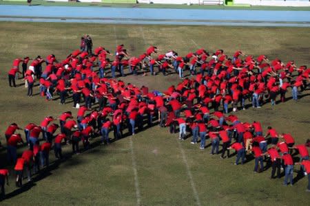 FILE PHOTO: Health workers and volunteers form a human ribbon to commemorate World AIDS day in San Salvador, El Salvador, December 1, 2017. REUTERS/Jose Cabezas/File Photo