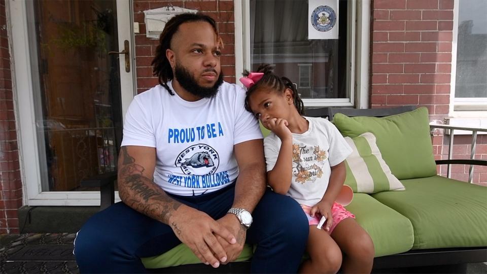 Nathan Fleming with his daughter Olivia sit on the porch of their home that is mostly in West York on August 14, 2023.