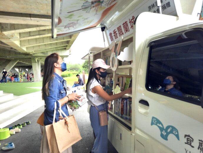 ▲宜蘭縣文化局行動巡迴書車開進綠色博覽會園區，引來愛書人借閱喜愛的書。（圖∕宜蘭縣文化局）