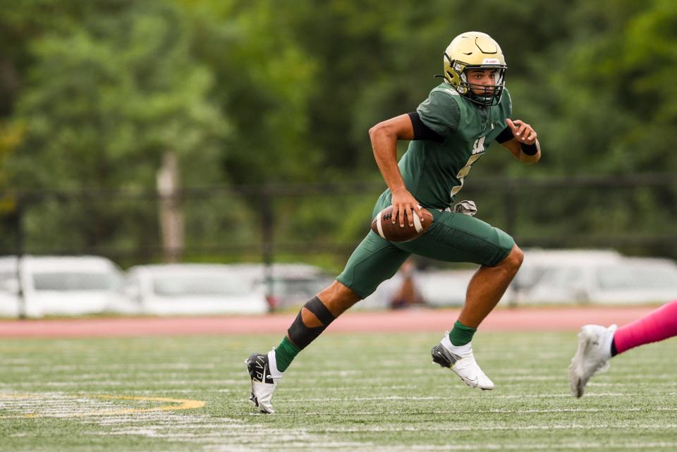 St. Joseph senior quarterback Luke Henrich eluding pressure in a football game in 2021 against Good Counsel (Md.)