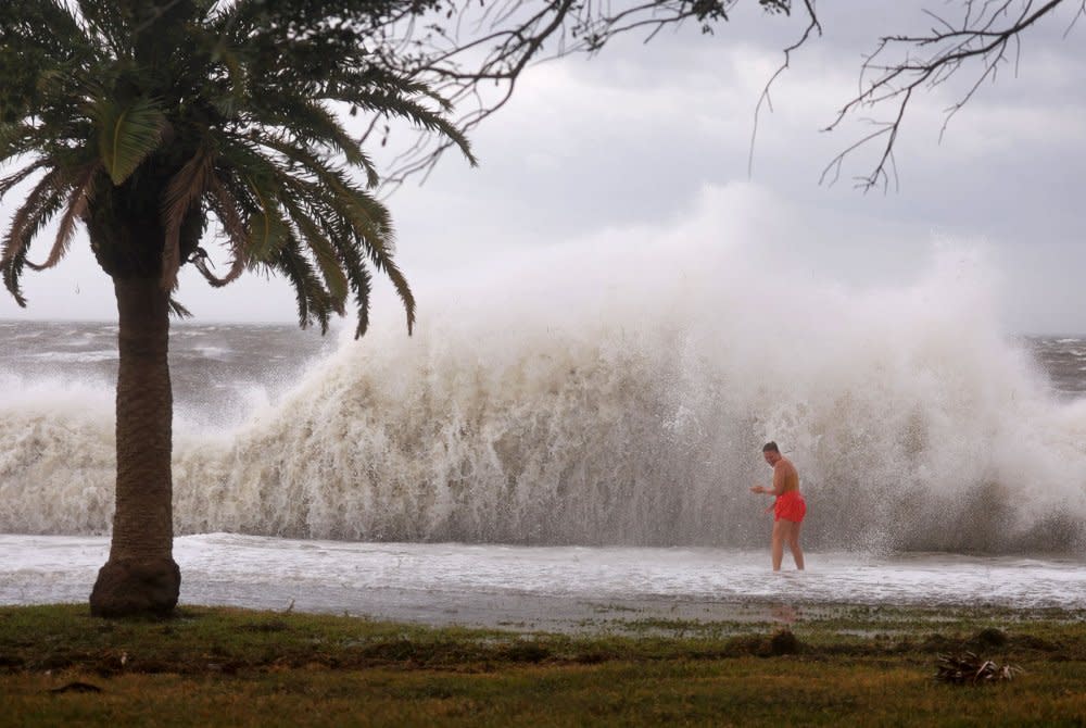 Tanner Flynn stands in shallow water near crashing waves as Hurricane Helene passes offshore in St. Petersburg, Flag. on Sept. 26.<span class="copyright">Joe Raedle—Getty Images</span>