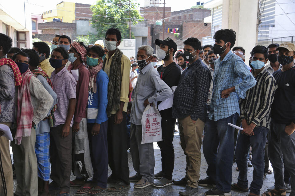 People wearing face masks as a precaution against the coronavirus line up without any physical distancing to get tested for COVID-19 at a government hospital in Jammu, India, Monday, April 19, 2021. India now has reported more than 15 million coronavirus infections, a total second only to the United States. (AP Photo/Channi Anand)
