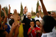 <p>Former Israeli president Shimon Peres (C) is seen with Israeli and Palestinian children during an event opening a year of training of an Israeli-Palestinian soccer program launched by the Peres Center for Peace, in Kibbutz Dorot, outside the Gaza Strip, September 1, 2014. (REUTERS/Amir Cohen) </p>