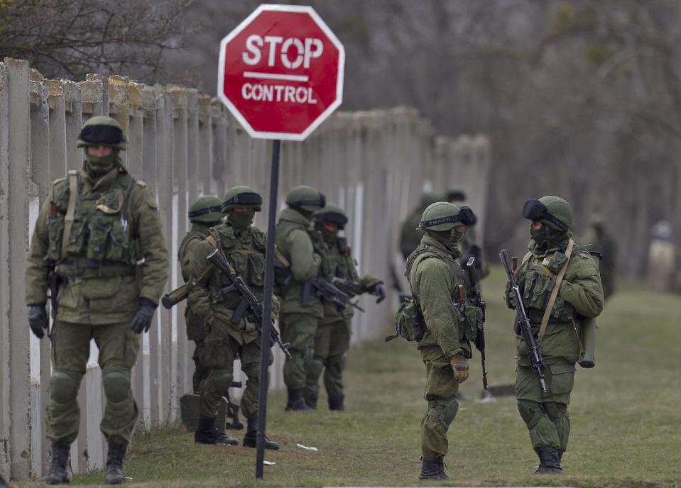 Pro-Russian soldiers stand outside a Ukrainian army base in Perevalne, Crimea, Wednesday, March 19, 2014. Crimea's self-defense forces on Wednesday stormed the Ukrainian navy headquarters in the Black Sea port of Sevastopol, taking possession without resistance a day after Russia signed a treaty with local authorities to annex the region.(AP Photo/Vadim Ghirda)